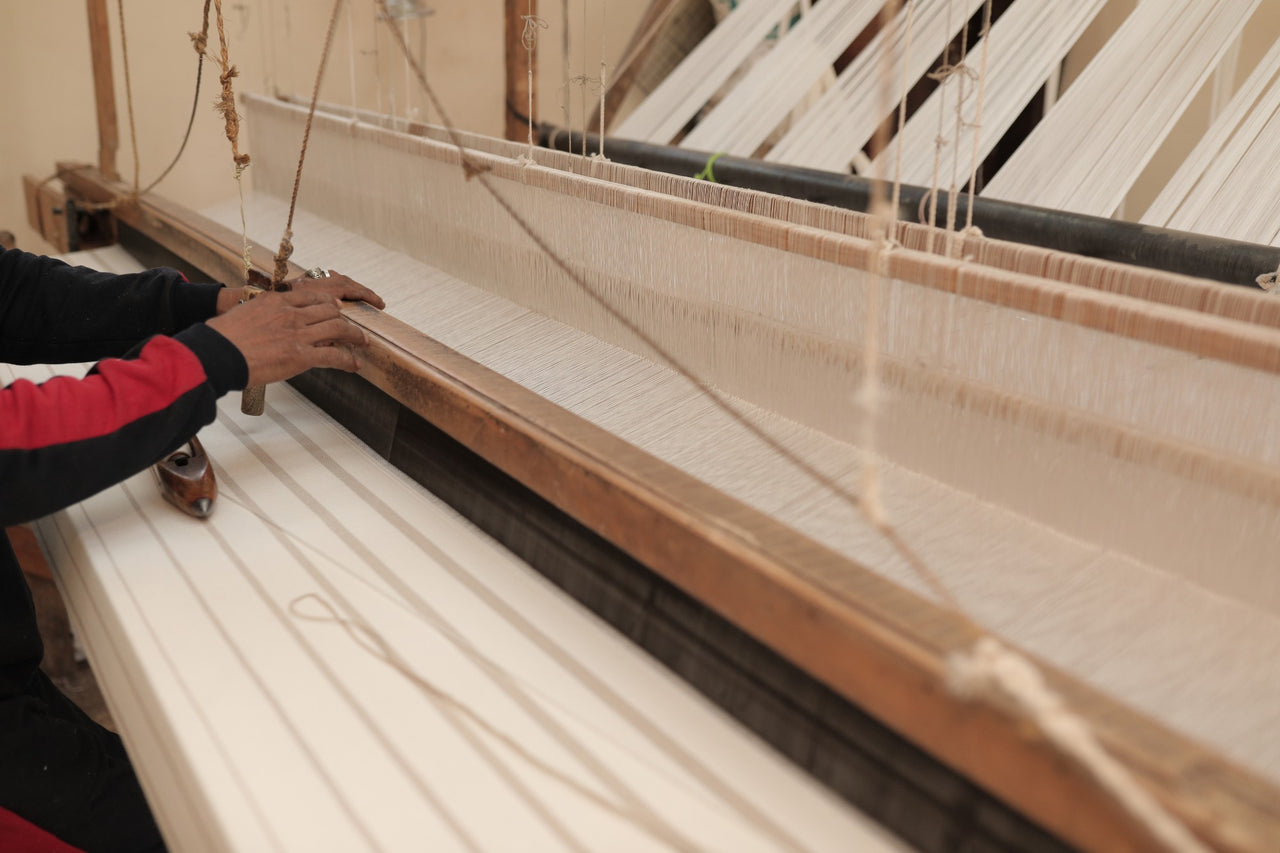 A weaver at a traditional wooden handloom